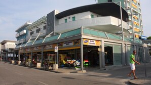 Un edificio de varios pisos con una arcada en la planta baja, un restaurante y una entrada visible.