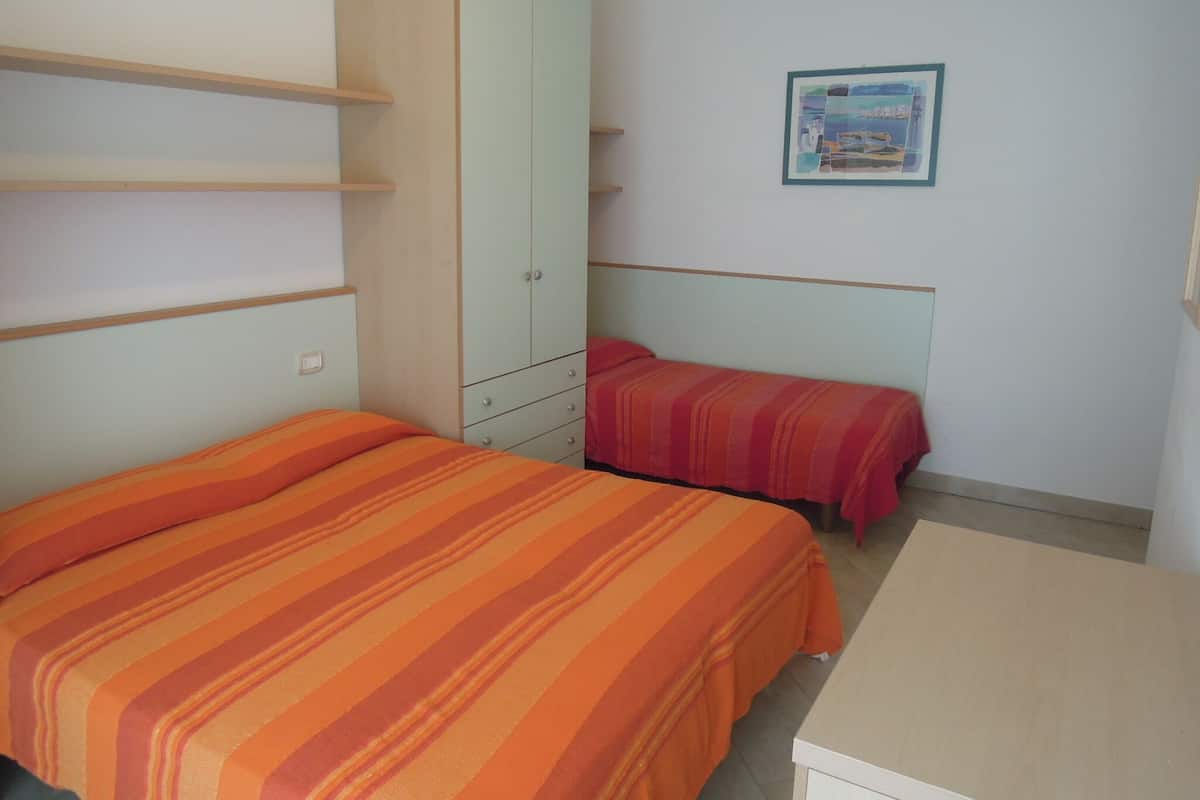 Una camera da letto con due letti, un armadio e un quadro appeso al muro.