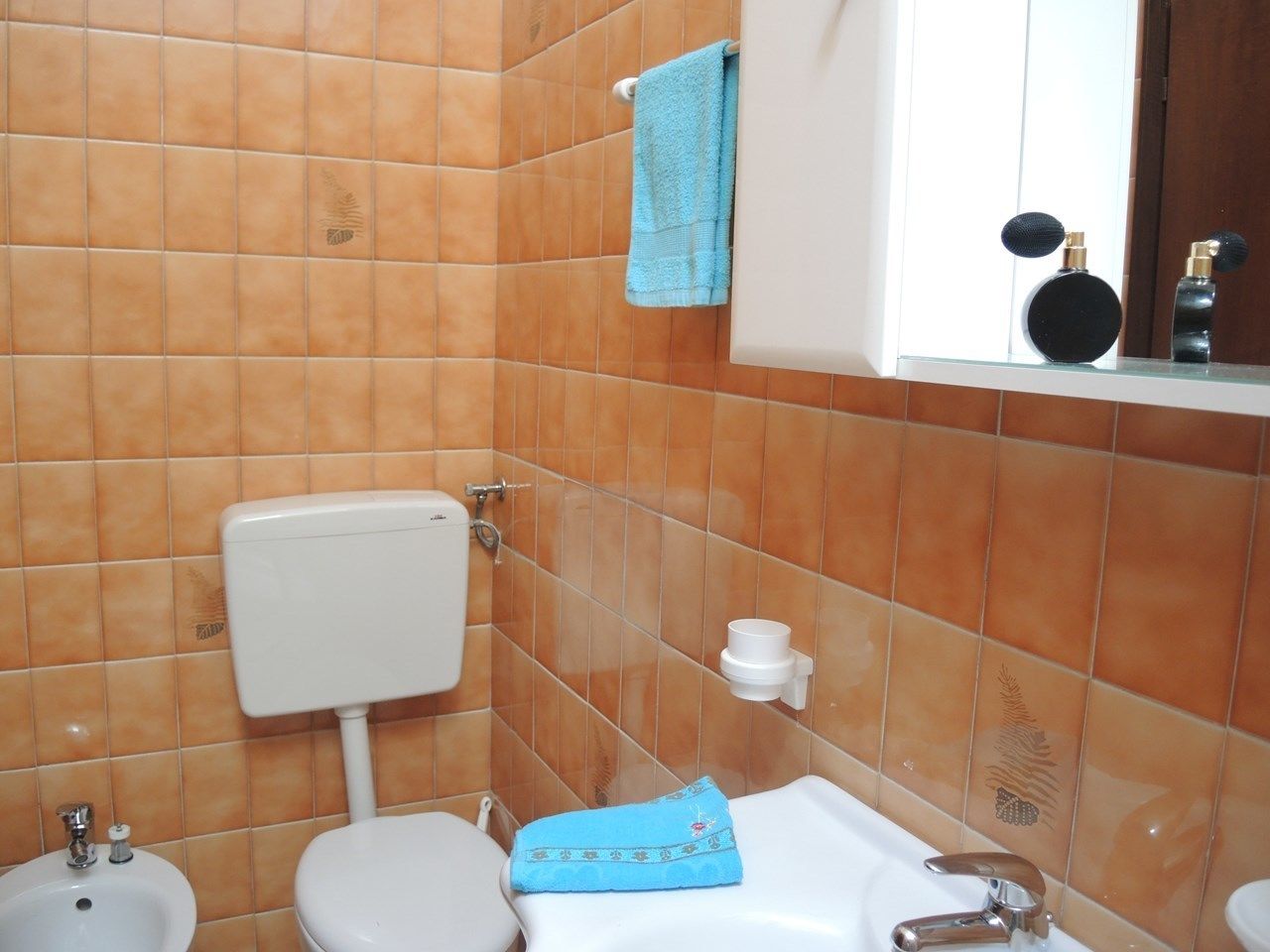 A bathroom with a white toilet, a bidet, and a sink.