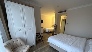 A hotel room with a single bed, a chair, a small table, and a wardrobe. - Biga Casa Grande Otel (Biga)