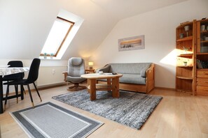 Una sala de estar acogedora con comedor, una estantería de madera y un tragaluz.