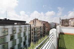 A high-rise building with multiple windows and balconies, surrounded by other buildings. - Habitat Apartments Alaia (Barcelona)