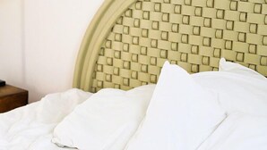 A bed with a woven headboard, white bedding, and a wooden nightstand. - Charming casa, 1 block to the beach- safe, quiet, excellent wifi, AC (Punta de Mita)