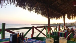 A table with a colorful tablecloth, two glasses of a beverage, and a bottle of water. - Charming casa, 1 block to the beach- safe, quiet, excellent wifi, AC (Punta de Mita)