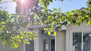 Une maison d’habitation avec un porche à l’avant, un petit jardin et une porte de garage.