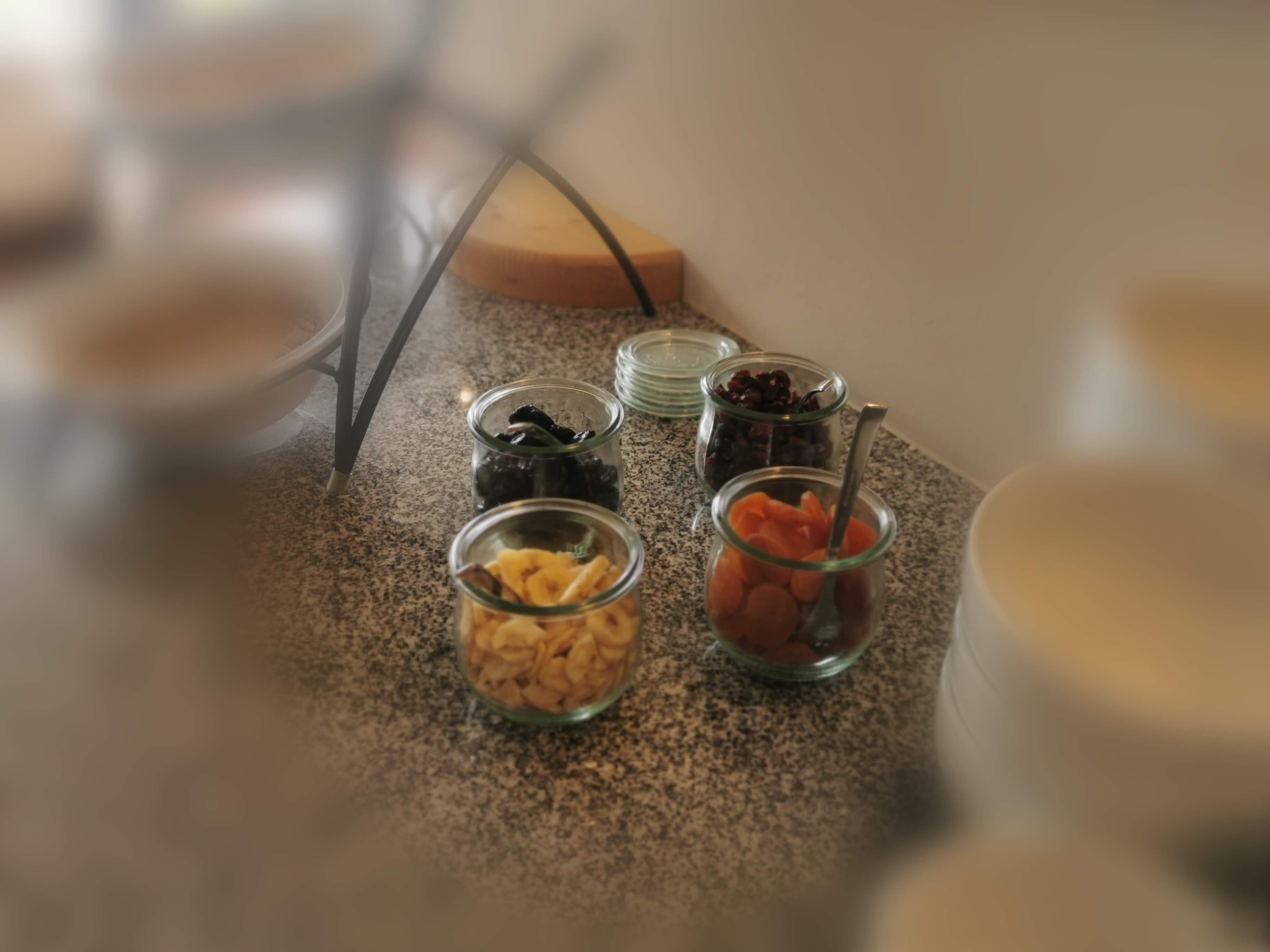 Un plan de travail sur lequel on trouve divers aliments, présentés dans de petits récipients en verre.