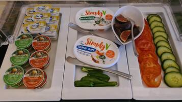 Mostrador refrigerado con diversas opciones veganas y vegetarianas, como hummus, yogur y patés vegetales.