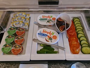 Mostrador refrigerado con diversas opciones veganas y vegetarianas, como hummus, yogur y patés vegetales.