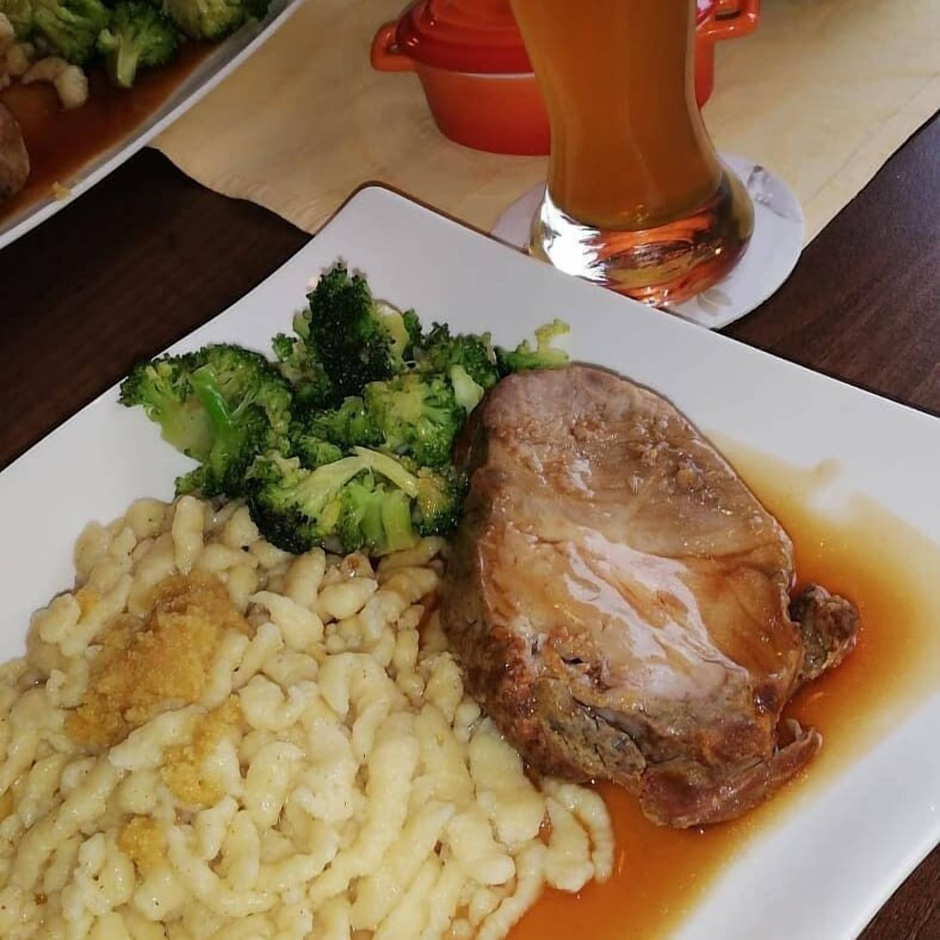 Ein Teller mit Fleisch, Brokkoli und einer Portion Nudeln.