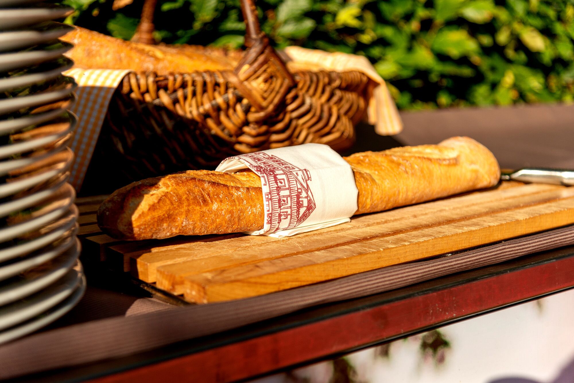 Une baguette et un panier en osier sur une surface en bois.
