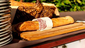 A baguette and a wicker basket on a wooden surface.