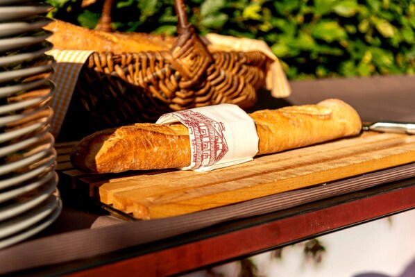 Una baguette y una cesta de mimbre sobre una superficie de madera.