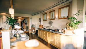 A kitchen with a wooden island, bar area, and various kitchen appliances. - Berghotel Hohe Mark (Reken)