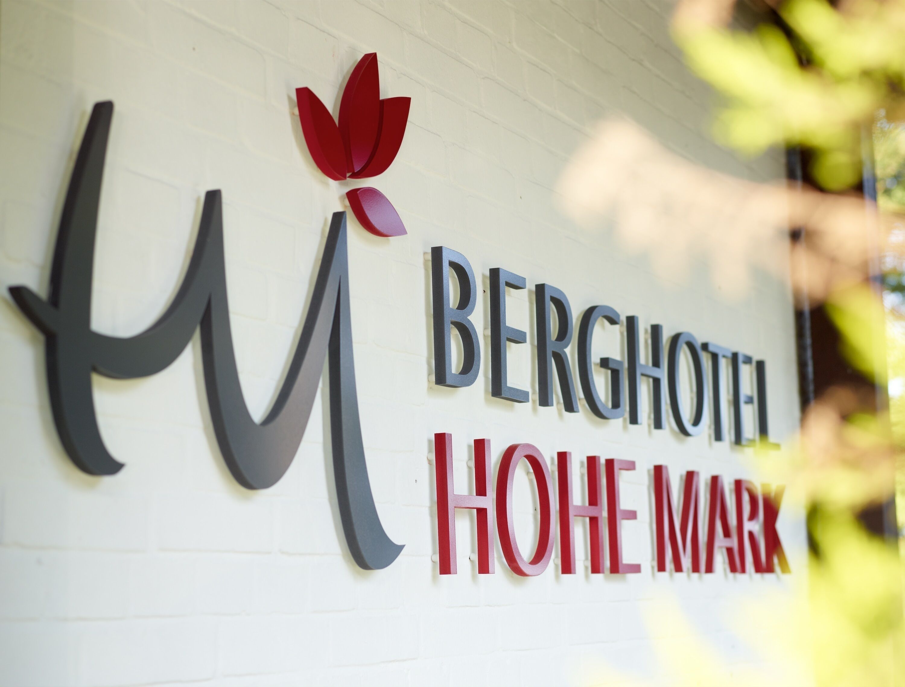 Un letrero de hotel con el nombre 'BERGHOTEL HOHE MARK' en letras grandes y negritas.