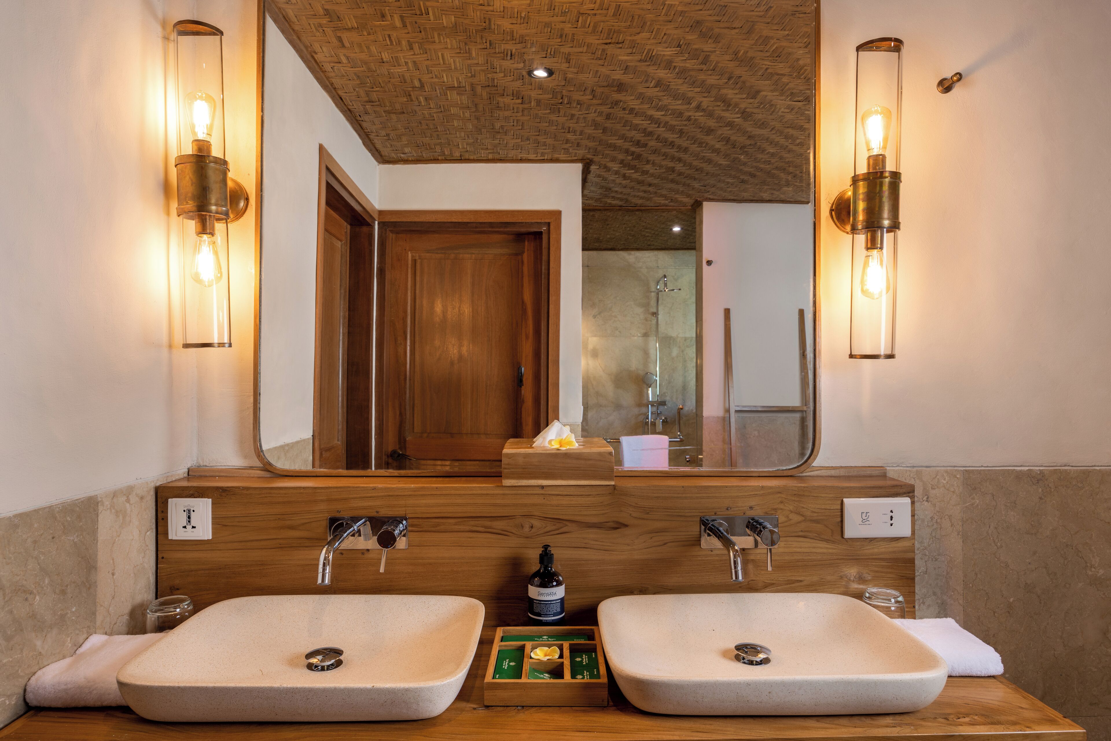 A bathroom with two sinks, wooden vanity, and a large mirror.