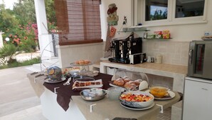 Un bufé de desayuno con diferentes opciones de comida, una cafetera y un refrigerador.