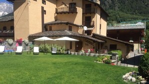 A building with a courtyard, outdoor seating, and a mountain backdrop.