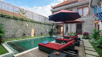 Una piscina al aire libre, sombrillas