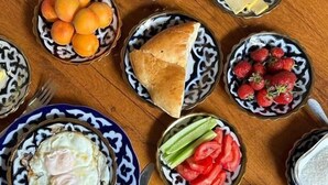 A table with various food items including eggs, fruits, and condiments. - B-House (Bukhara)