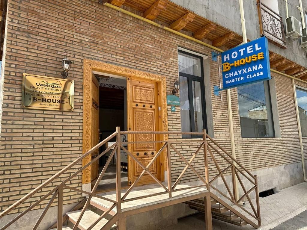 L’entrée d’un hôtel, avec une porte en bois et un escalier menant à l’entrée.
