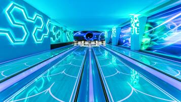 A bowling alley with neon-lit walls and a central bowling lane.