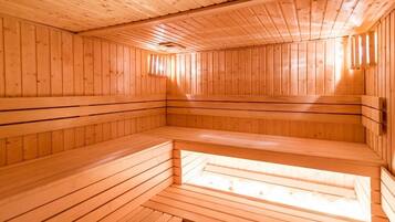 Sauna, jossa on puuseinät ja -lauteet, kattovalaisin ja pieni ikkuna.