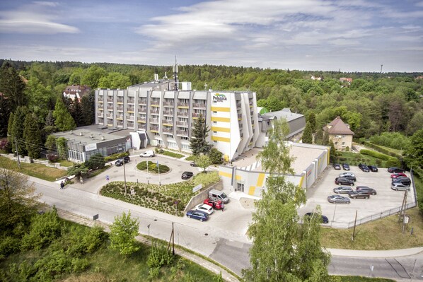 A multi-story hotel with a central courtyard, surrounded by greenery and a parking lot. - Hotel Polanica Resort & SPA (Polanica-Zdroj)