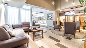A modern hotel lobby with a sofa set, a coffee table, and a television. - Hotel Polanica Resort & SPA (Polanica-Zdroj)