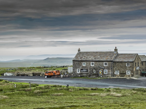 A stone building with a sign that reads "The Old Inn." - The World Famous Tan Hill Inn (Richmond)
