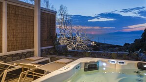 A hot tub with a view of the sea at dusk. - Klidon Dreamy Living Suites (Mykonos)