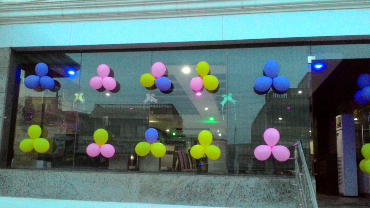 A window with colorful balloon decorations.