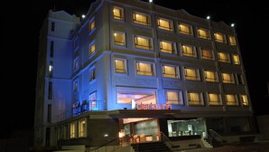 A multi-story hotel with illuminated windows and a visible entrance.