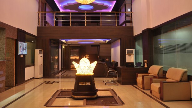 A lobby with a reception desk, seating area, and a decorative welcome sign.