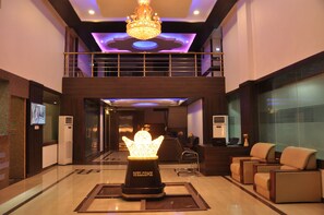 A lobby with a reception desk, seating area, and a decorative welcome sign.