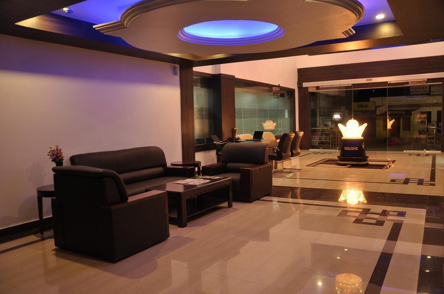 A modern lobby with a sofa, coffee table, and a decorative light fixture.