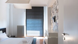 Un dormitorio moderno con una cama grande, una mesita de noche, un radiador y una pared con un diseño estampado.