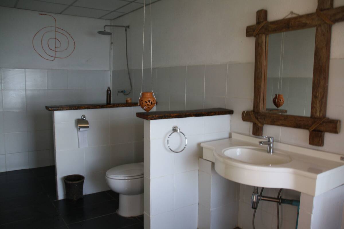 A bathroom with a toilet, sink, and mirror.