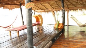 A wooden deck with a hammock, a bench, and a sign that reads "MASSAGE".
