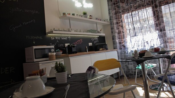 Un café avec un tableau noir servant de menu, un four à micro-ondes et une machine à café.