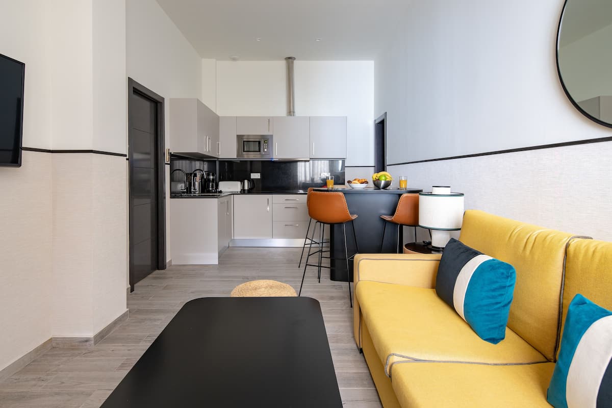 Un appartement moderne comprenant une cuisine, un coin repas et un salon.