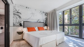 A modern hotel room with a large bed, two pillows, a nightstand, and a wall mural. - Slow Suites Setas (Seville)