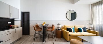 Una cocina moderna con comedor, un sofá y un espejo redondo en la pared.