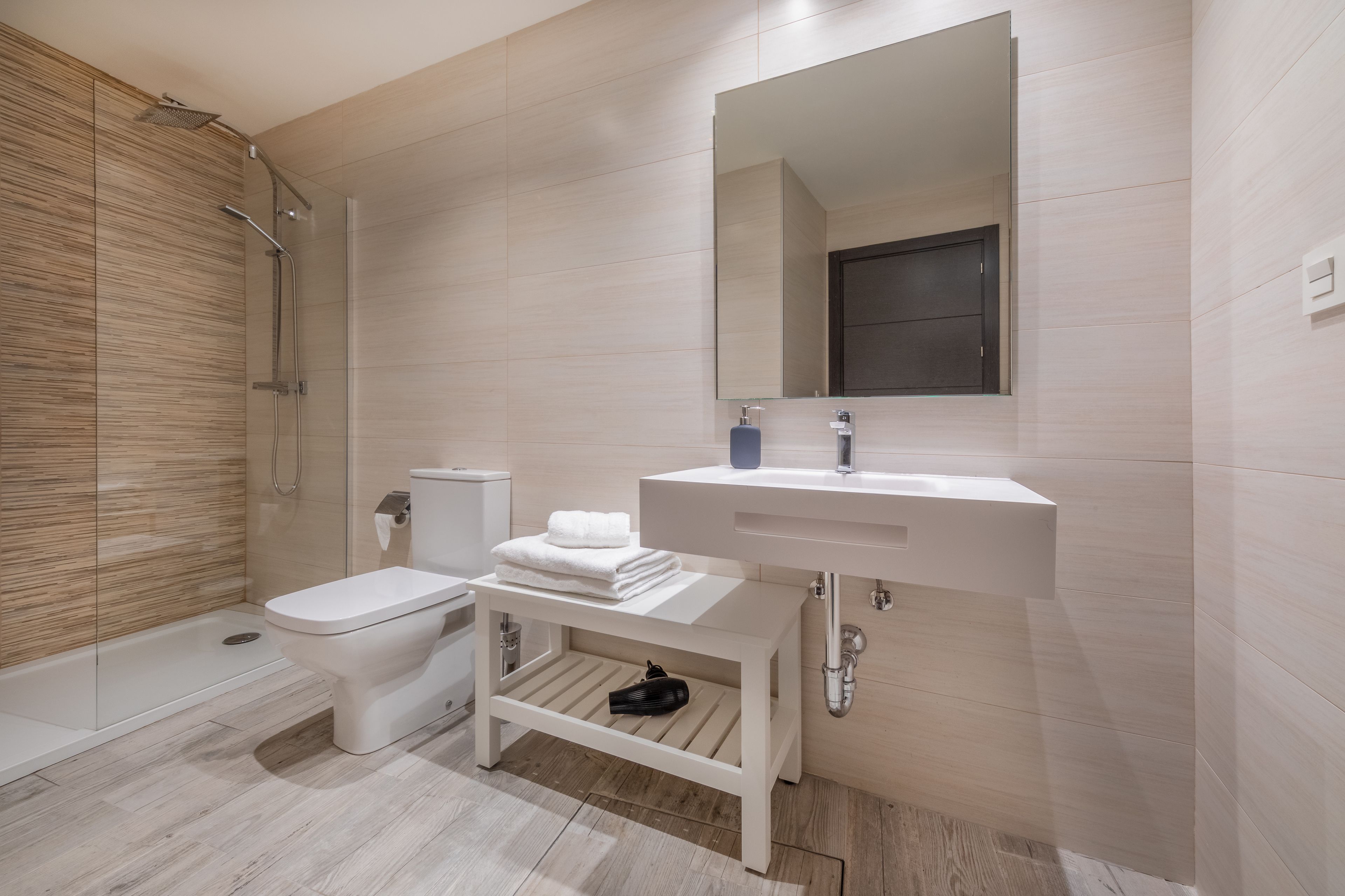 A modern bathroom with a toilet, sink, and shower.