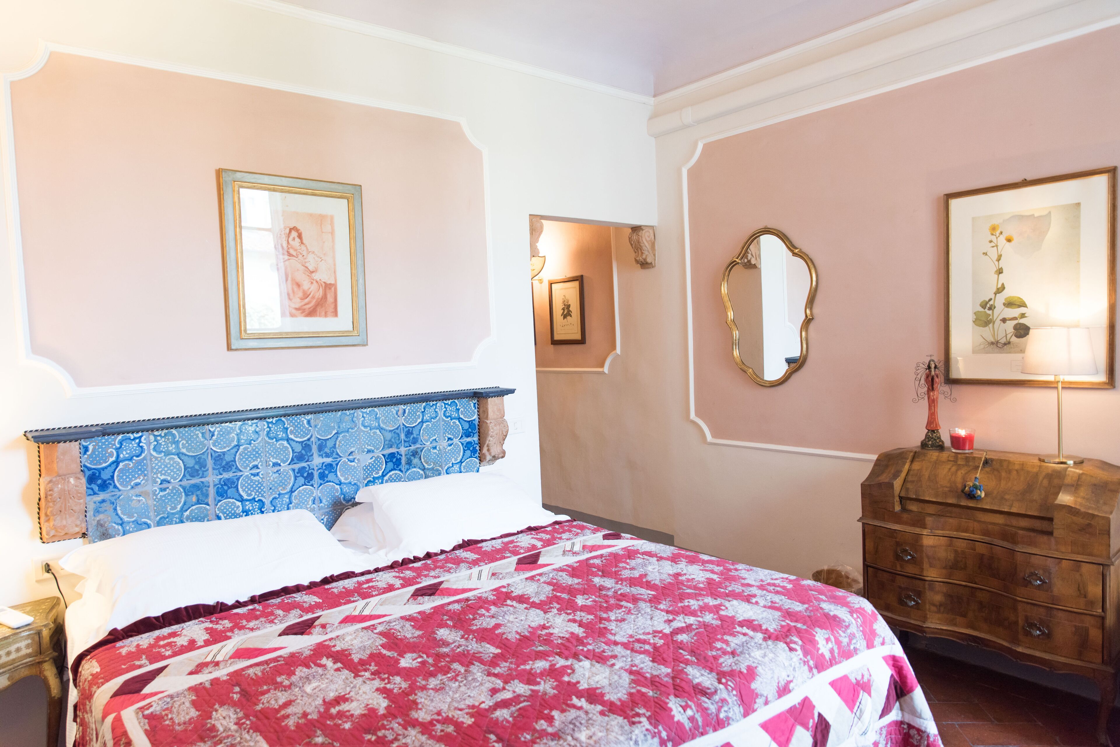 Un dormitorio con cama, cómoda y espejos en la pared.