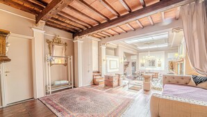 Una habitación amplia con un espejo grande y ornamentado, un sofá mullido y una alfombra estampada.