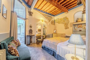 A bedroom with a bed, a desk, a chair, a sofa, and a lamp. - Relais Grand Tour (Florence)