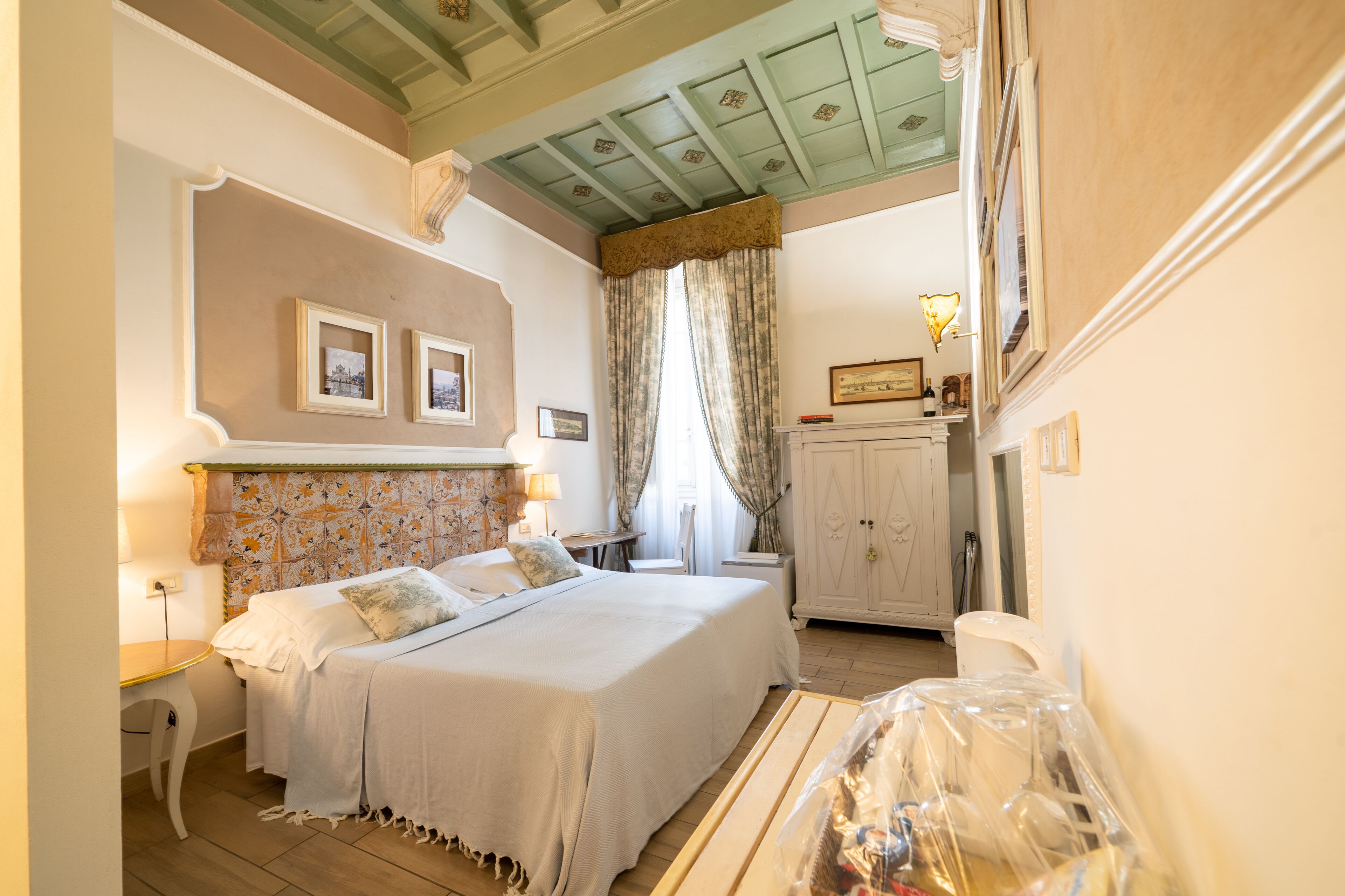 A bedroom with a bed, bedside tables, a dresser, and a window with curtains.
