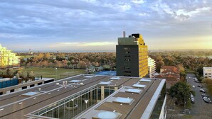 Un edificio moderno con techo plano, ventanas amplias y una antena destacada.