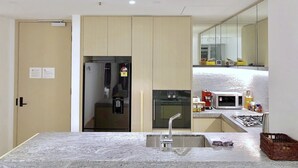 A modern kitchen with a built-in refrigerator, oven, and microwave. - Fawkner Apartment Bay-view LXI (Melbourne)