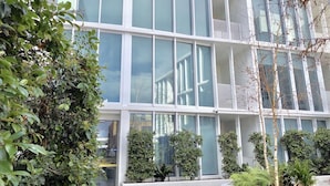A modern building with large windows and a balcony. - Brand New Stunning Home with Garden (Brighton)